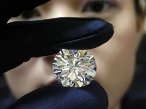 Женщина держит в руках бриллиант